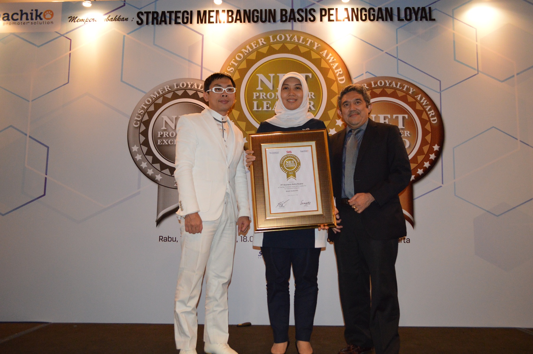 VP Service Management Asuransi Astra, Mustika Wulandari (tengah) saat menerima penghargaan Net Promoter Loyalty Award dari Majalah SWA