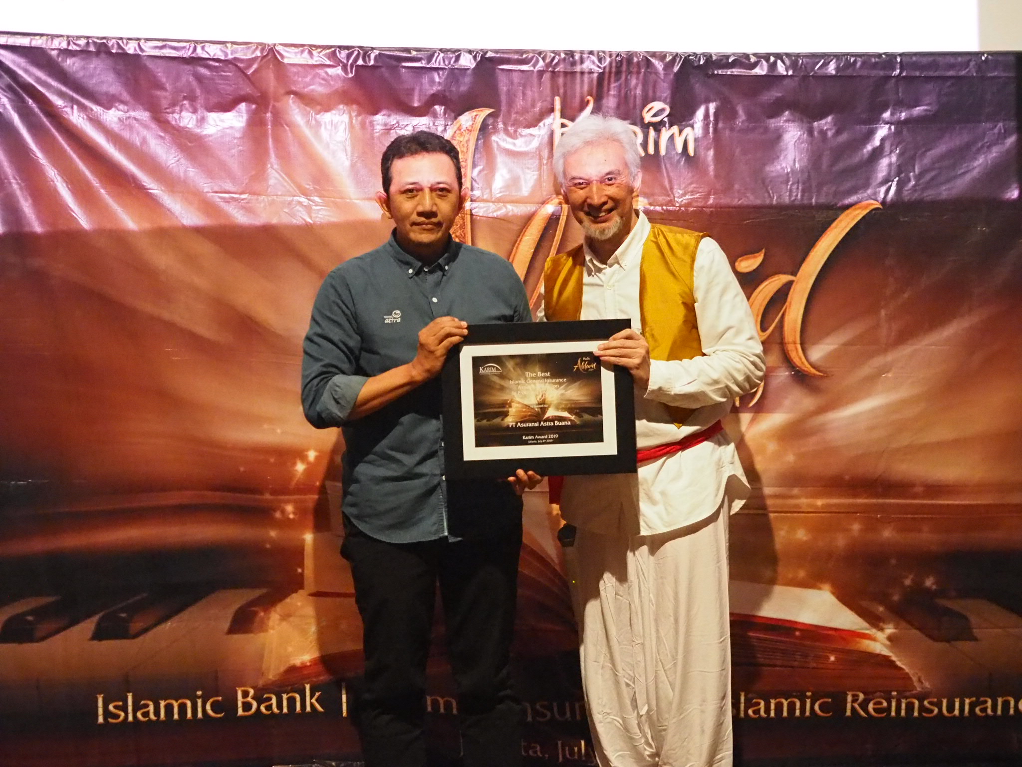 SVP Corporate Secretary, Compliance, & Risk Management Asuransi Astra, Eddy Ismanto (kiri) saat menerima penghargaan.